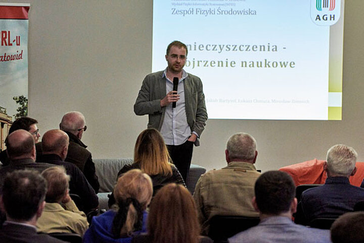 Na zdjęciu Michał Gałkowski podczas wykładu. Przed nim siedzący ludzie