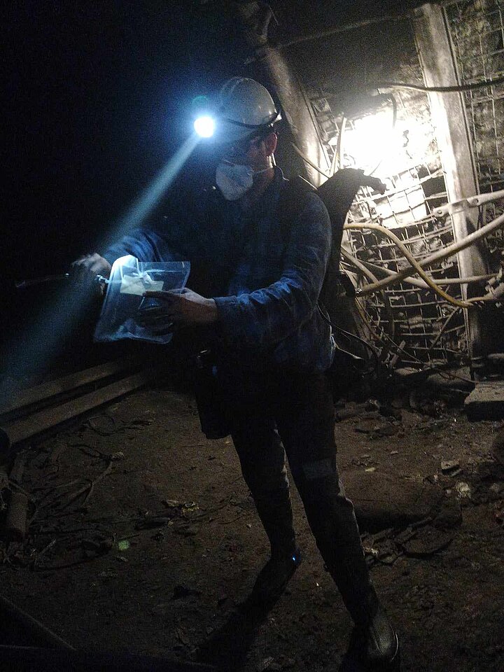 Na zdjęciu człowiek w kopalni robiący pomiar